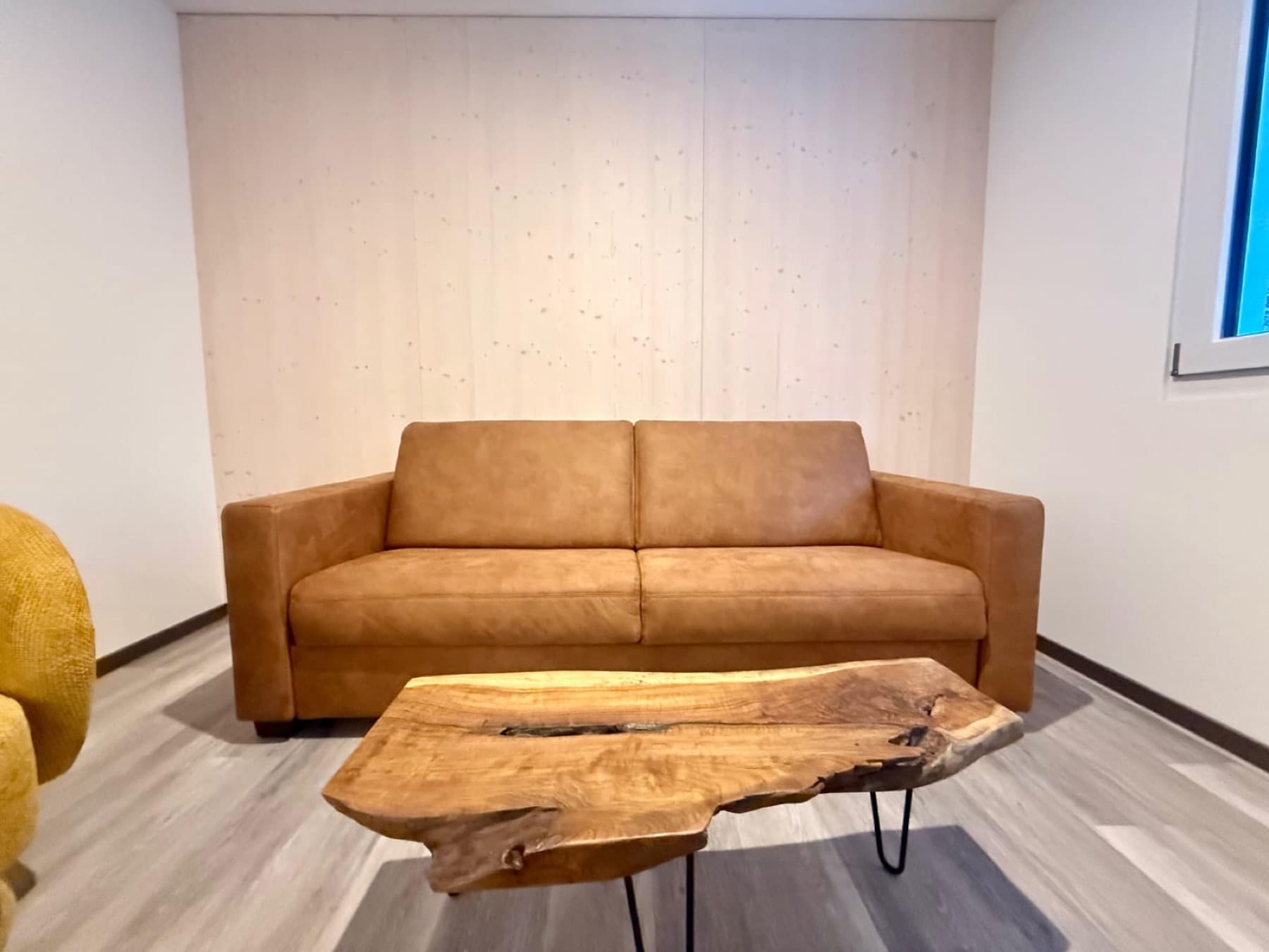 Wohnzimmer mit Massivholz-Wand und Designersofa