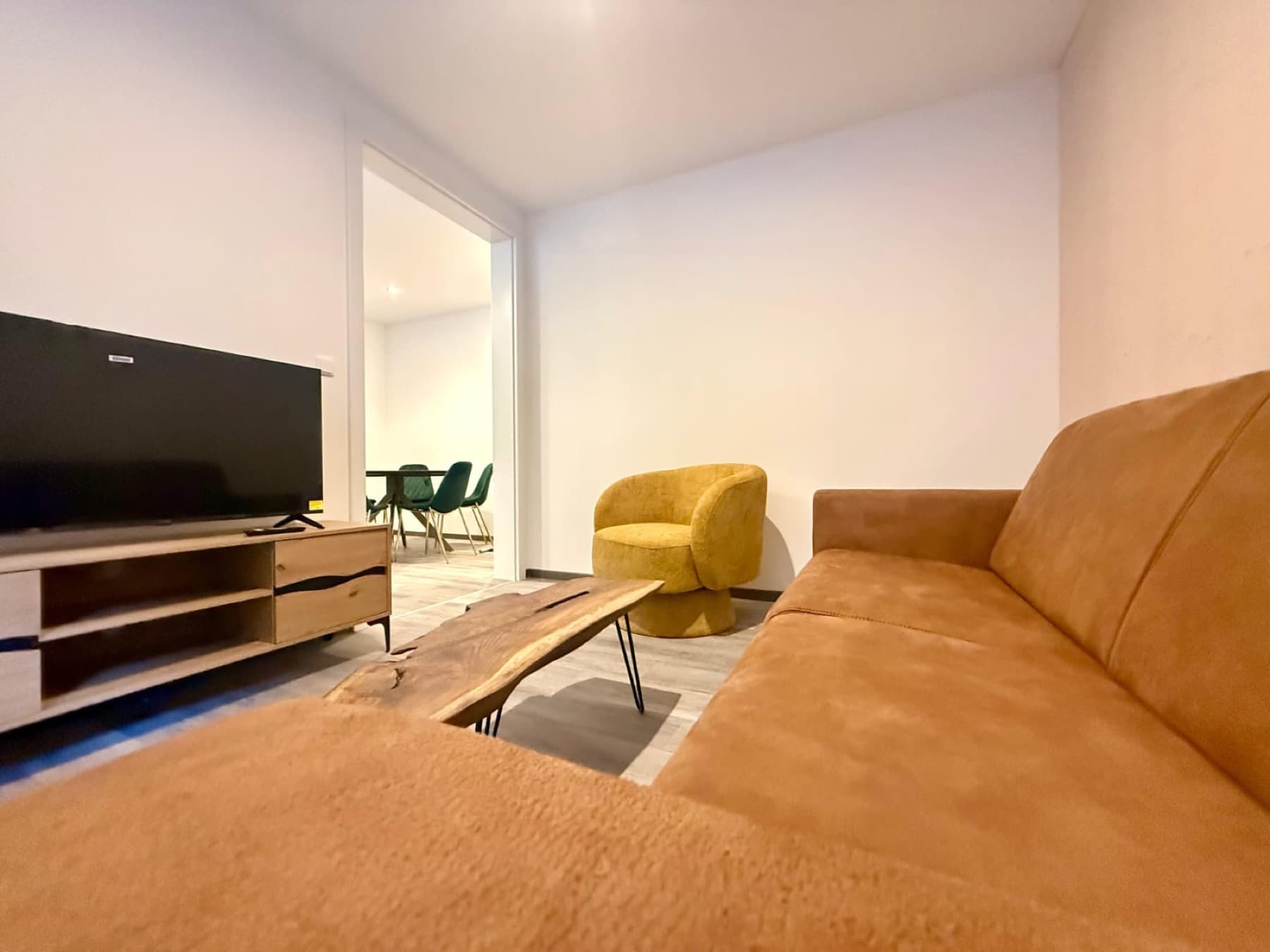 Wohnbereich mit Sofa, Sessel und Wohnwand